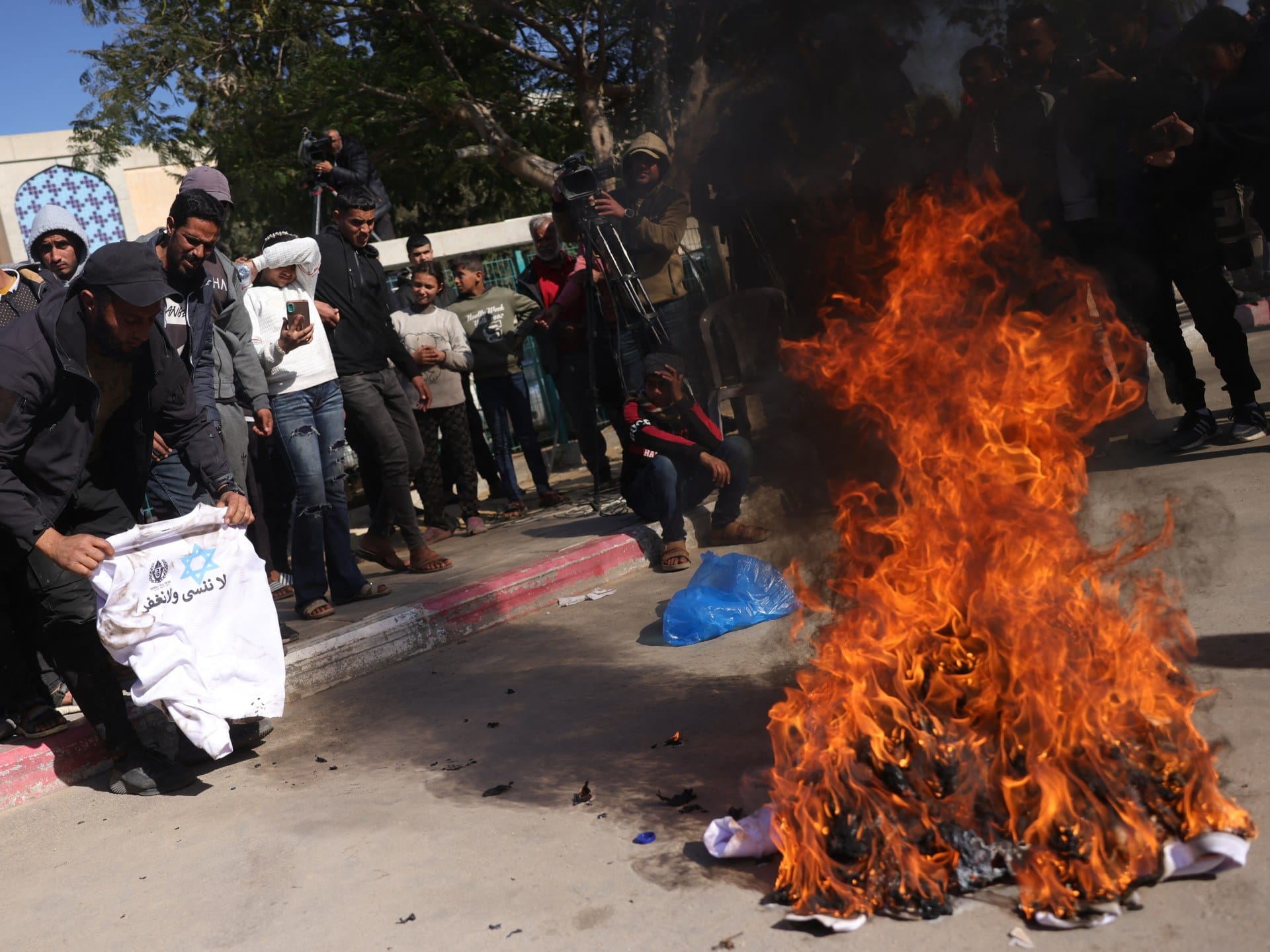 Palestinians burn ‘humiliating’ shirts after release from Israeli prisons | Israel-Palestine conflict News